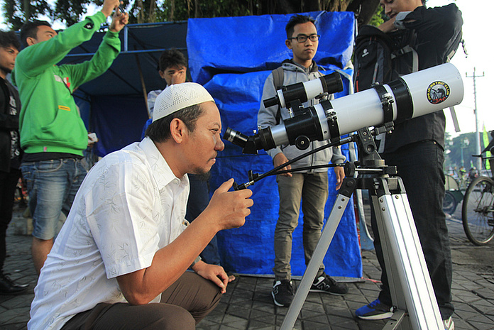 Ein Mann clickt durch ein Teleskop in die Ferne