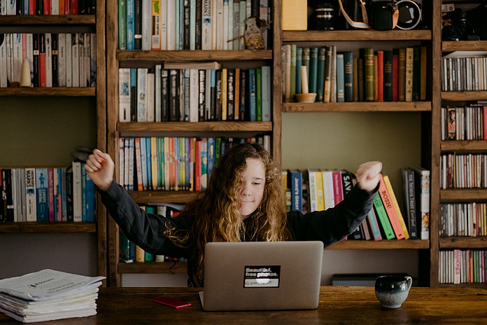 Eine Frau sitzt an ihrem Schreibtisch am Laptop