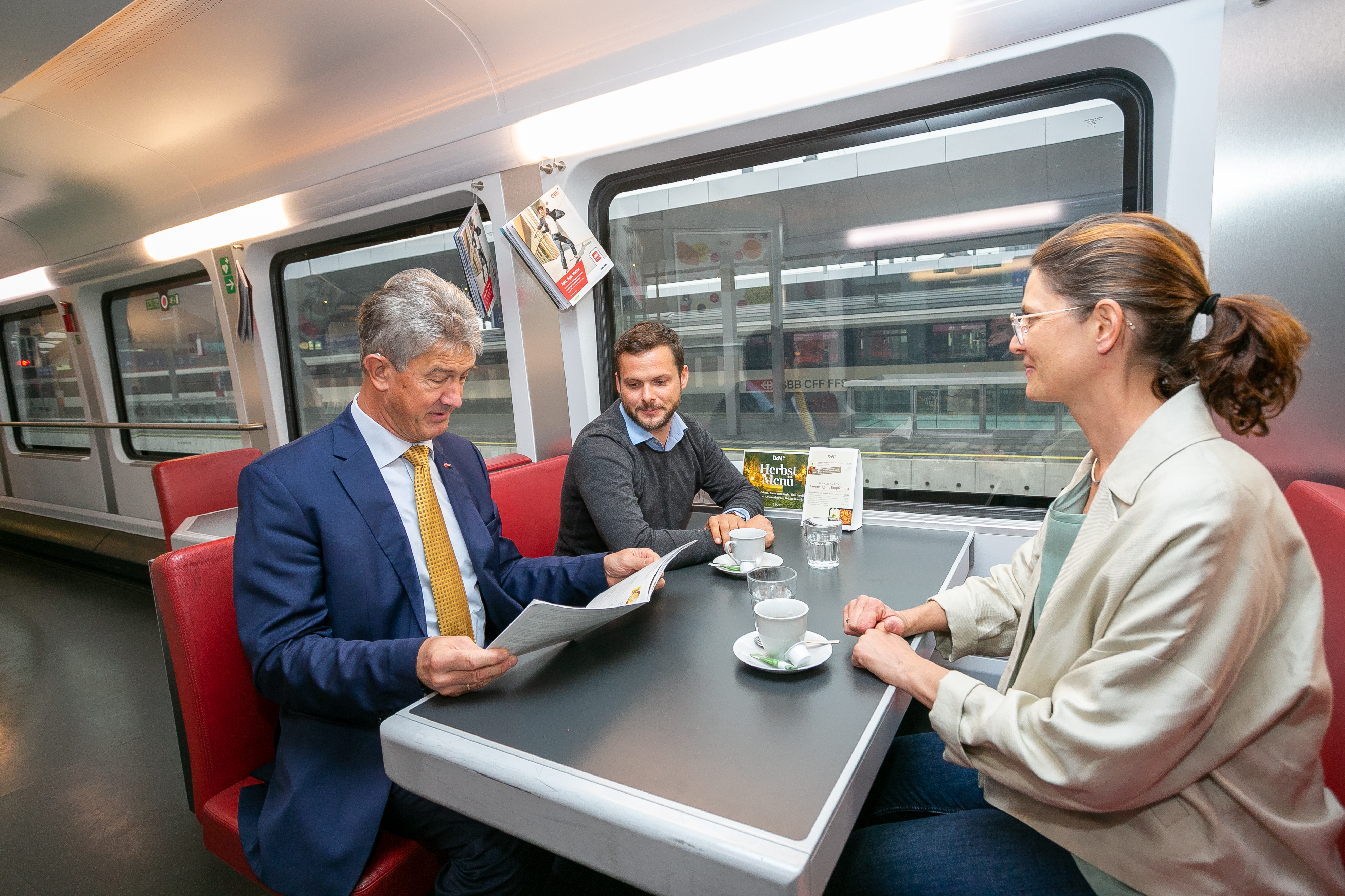 Drei Menschen fahren mit der ÖBB